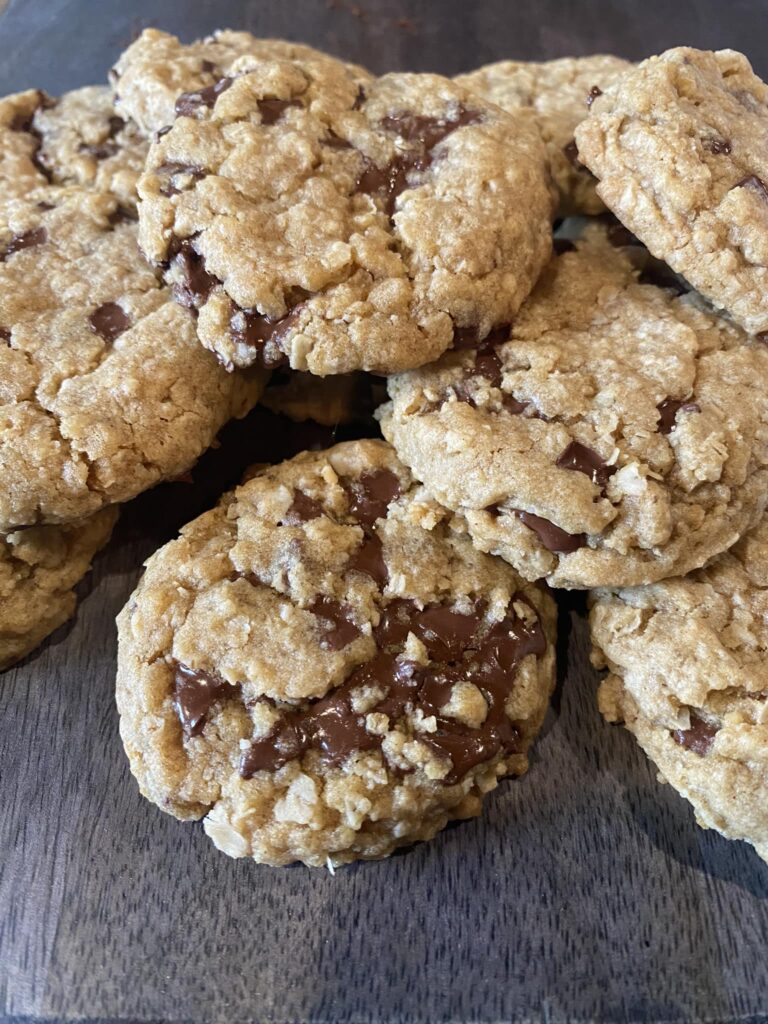 Breaking apart a warm oatmeal cookie to show melted chocolate chunks.