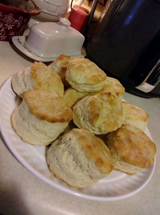 Close up of the flaky, layered interior of a butter-topped buttermilk biscuit.