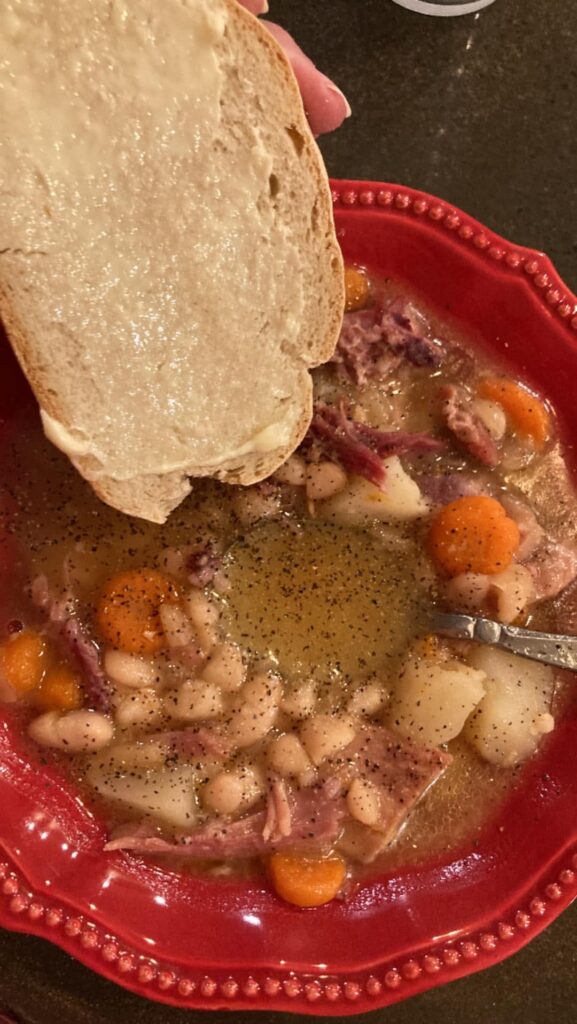 Real, unedited photograph of simmering Bean and Ham Bone Soup on the stove